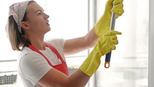 Beautiful Young Housewife Washes the Windows and Dances