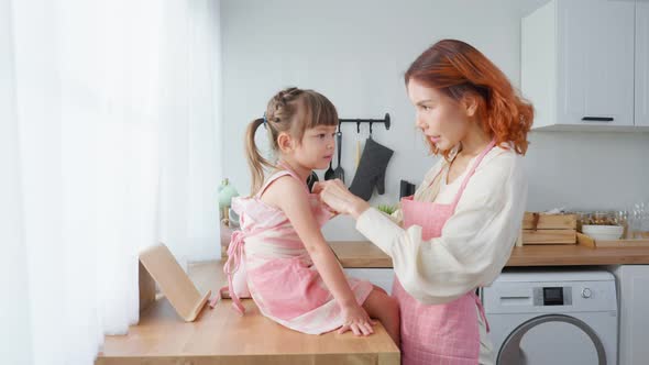 Asian beautiful young mother cooking foods with baby kid in kitchen.