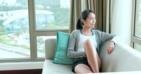 Woman looking out of window at home 