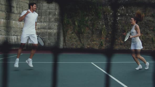 Woman and man playing tennis on a court