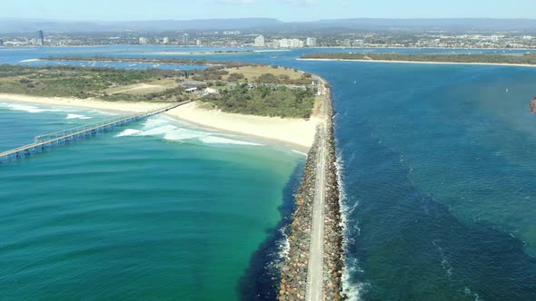 Seawall and sand pumping facility in foreground slowly panning to sight Surfers Paradise , Gold Coas