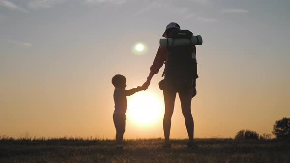 Mother with Little Boy Hiking Adventure with Child on Family Trip. A Woman with a Backpack