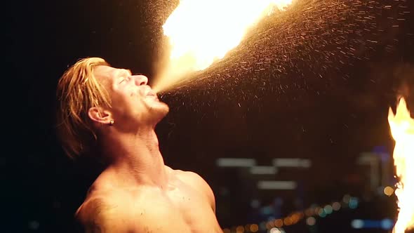 Young Blond Male Breathes Out Large Stream of Fire Making Fireball