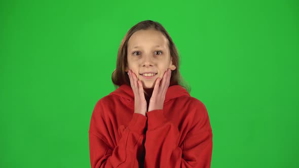 Girl Is Surprised and Very Rejoiced in Studio on Green Background