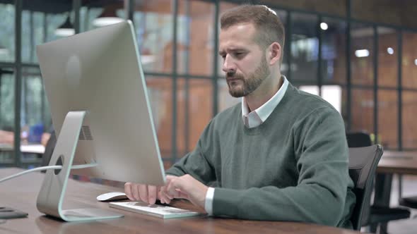 Tired Man Having Back Pain While Working on Desktop