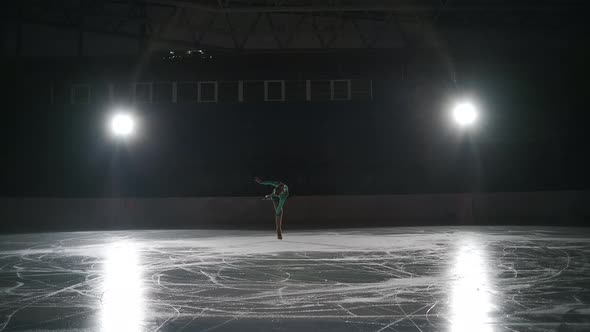 Slow Motion Cinematic Shot of Young Female Artistic Figure Skater is Performing a Woman's Single