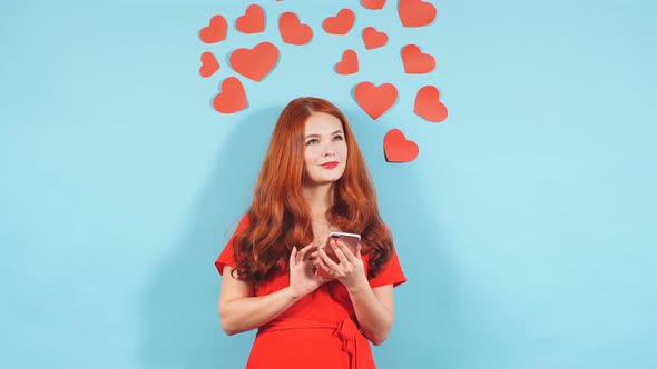 Portrait of Dreamy Woman with Smartphone Isolated Over Blue Background.