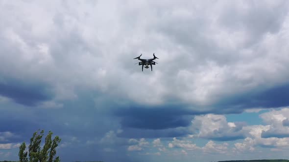 Flying drone over fields. Drone capturing aerial shots using camera against a blue sky