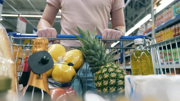 Shopping Cart Filled with Products is Being Pulled By a Man