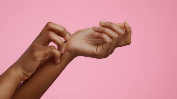 Closeup Of Black Female's Hands Scratching Itchy Skin Pink Background