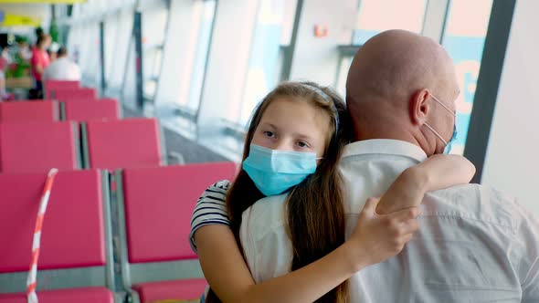 Portrait, Girl Child in Protective Mask Hugs Her Father, at Airport, Against Background of Empty