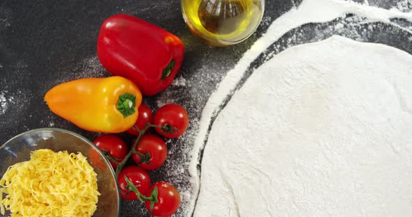 Pizza flour with vegetables on table