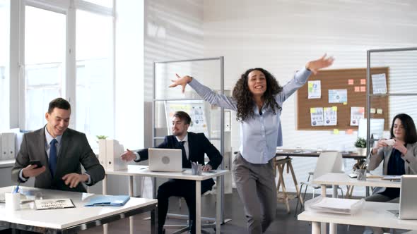 Carefree Woman Dancing in Front of Her Business Team in Office