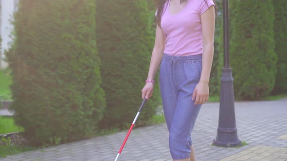 Young Visually Impaired Asian Woman with a Cane Is in the Park Slow Mo