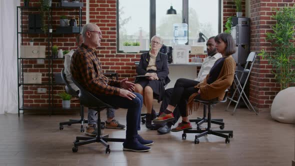 Senior Man Making Confession in Front of People and Therapist at Aa Group Meeting