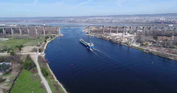 Aerial shot of cargo ship passing under the Asparuhov bridge in Varna, Bulgaria.