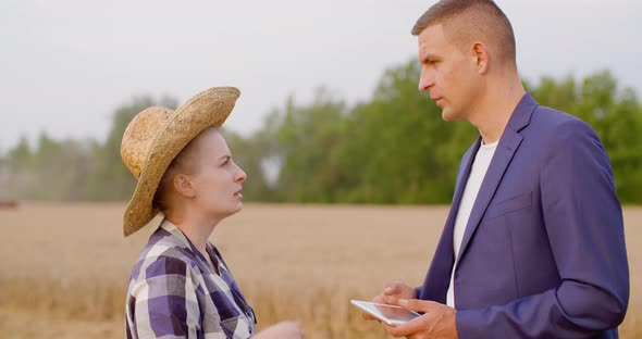 Female Farmer Discussing With Businessman On Farm