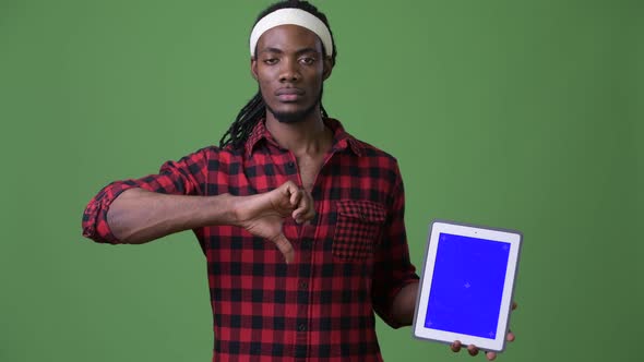 Young Handsome African Man with Dreadlocks Against Green Background