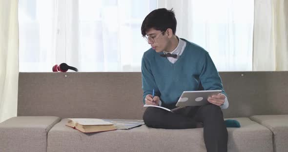 Middle Shot of Brunette Caucasian University Student in Eyeglasses Sitting with Tablet and Books on