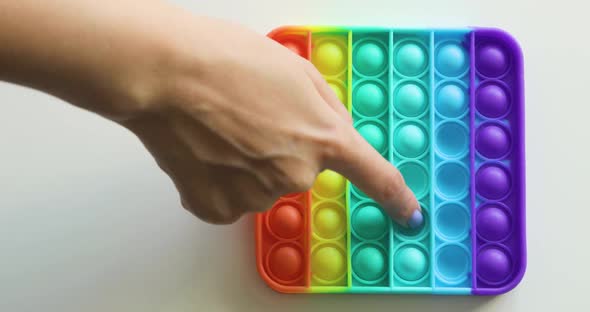 Closeup of Girl Hands Playing with Popit Push Pop Bubble Fidget Toy