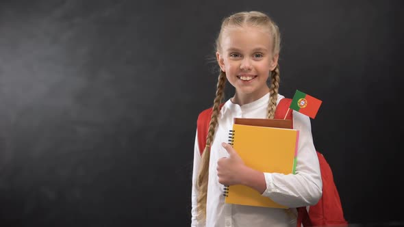 Happy Pupil Holding Books With Portugal Flag, Ready to Learn Foreign Language