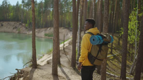 Back View of One Black Man Looking on Mountain and Lake