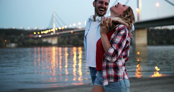 Beautiful Couple in Love Walking on Beach at Sunset