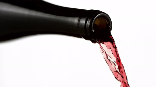 Super Slow Motion Detail Shot of Pouring Red Wine From Bottle Isolated on White at 1000Fps