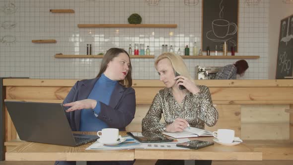 Busy Women Using Gadgets Working Remotely in Cafe