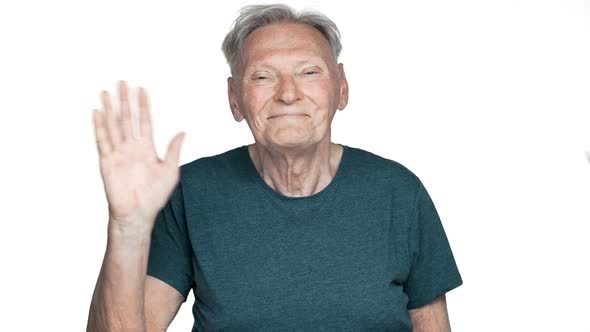 Portrait of Retired Man 80s with Candid Smile Greeting or Welcoming While Waving Hand at Camera Slow