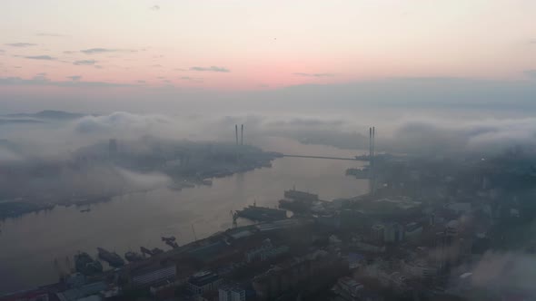 Drone View of the City Bay and Big Bridge Covered with Fog at Sunset