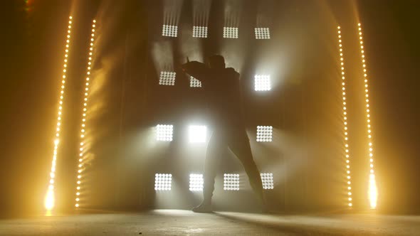 Silhouette of a Talented Young Hip Hop Dancer. Hip Hop Street Dance on a Stage in Dark Studio with