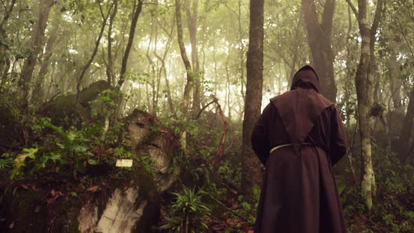 Christian catholic religious monk friar walking and meditating praying in a beautiful forest