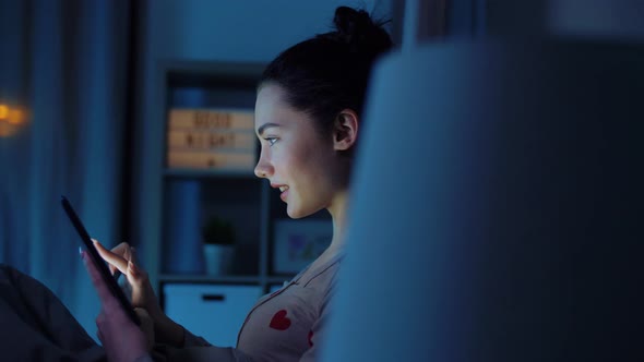 Teenage Girl with Tablet Pc in Bed at Night