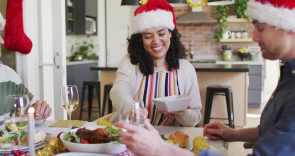 Happy group of diverse friends celebrating meal at christmas time