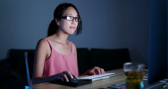 Young woman working on computer at night 