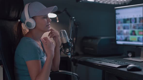 Beautiful Woman In A Cap And White Headphones Leads A Live Stream