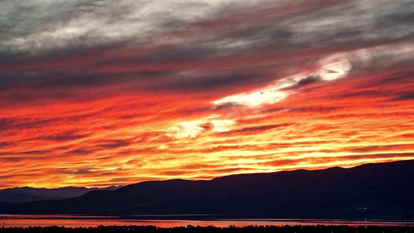Timelapse of fiery sunset over Utah Lake zoomed across the valley