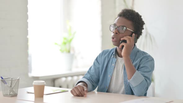 Young African Man Talking on Phone in Office