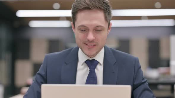 Portrait of Businessman Celebrating Success on Laptop