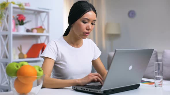 Young Woman Working Laptop at Home, Eating Green Apple, Healthy Snack, Vitamins