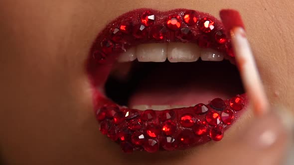 Luxury Woman with Rhinestones on Her Lips. Slow Motion. Close Up