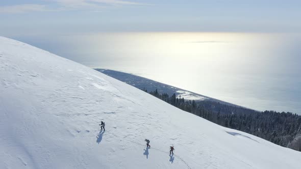 Group People Hiking Uphill Skitour in Snowy Mountain for Snowboarding Freeride