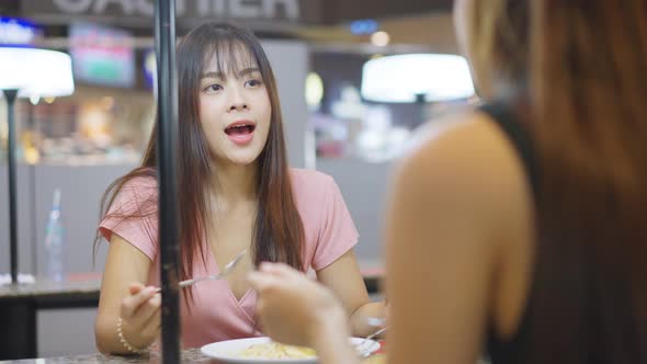 Asian young beautiful woman having lunch with friend in a restaurant with happiness and fun.