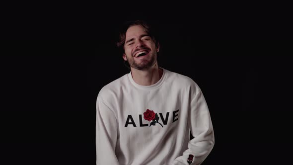 Trendy Young Man laughing at camera, happy gesture, wide, black background