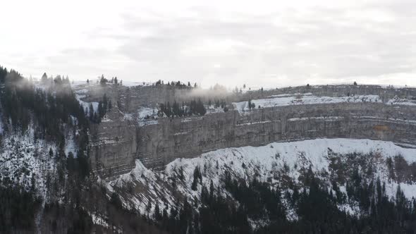 Aerial of snow covered mountain ridge and forest