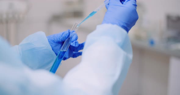 Portrait of Female Scientist Analyzing with a Pipette at Laboratory