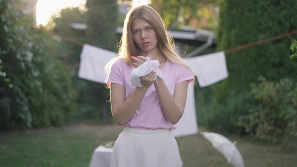 Front View Portrait of Confident Young Woman Rubbing Hands Looking at Camera