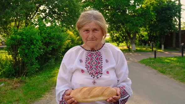 Grandmother with Ukrainian Bread in Her Hands