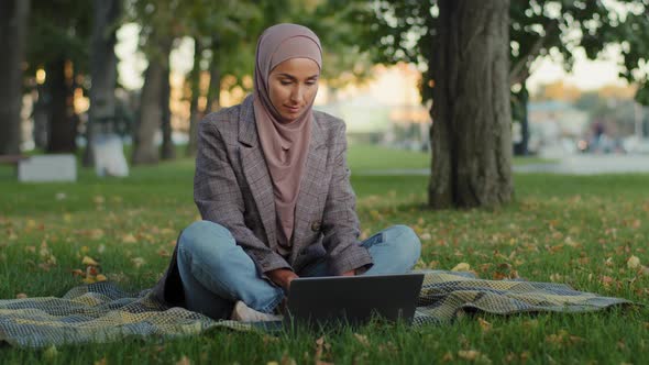 Muslim Arab Islamic Student Girl in Hijab Business Woman Freelancer User Uses Laptop Sitting on